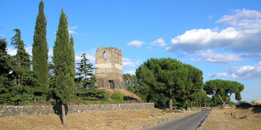 Appian Way in Rome, an ancient road built amidst lush greenery and historic structure
