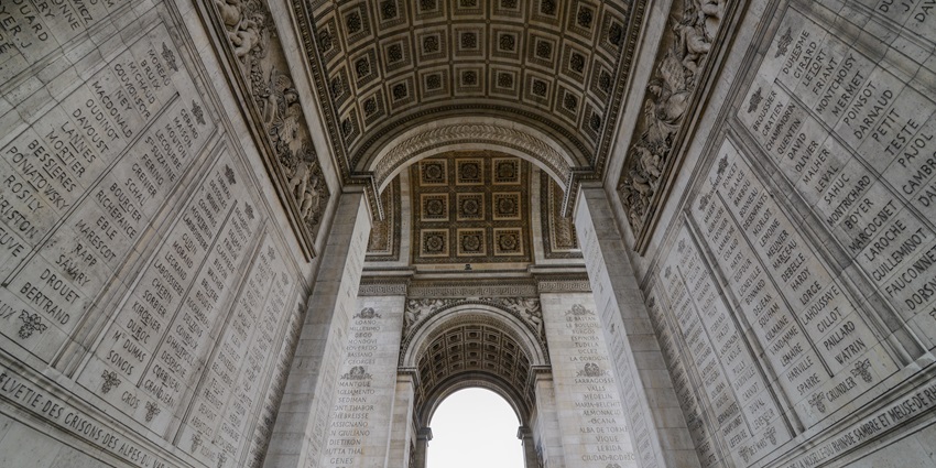 The iconic Arc de Triomphe monument with traffic circling below on the Champs-Élysées.