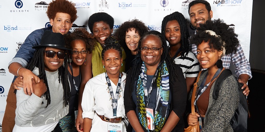 A picture of attendees of the iconic New Orleans Film Festival in front of the event banner
