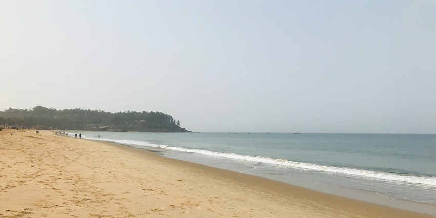 Vagator Beach view with cliffs and waves showing how much does a Goa trip cost