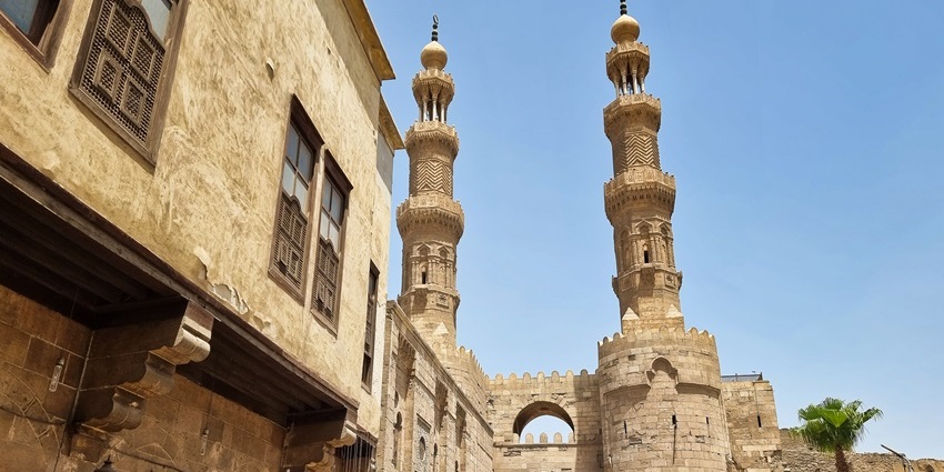 Majestic medieval gate towers of Bab Zuweila under a clear blue sky.