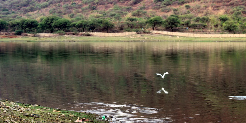 A peaceful blue lake surrounded by hills, perfect for a serene nature hike in August.