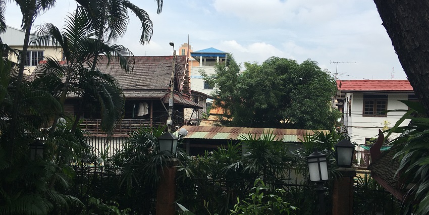 Ban Khrua Nuea with multiple buildings and houses, plants and unique street lamps