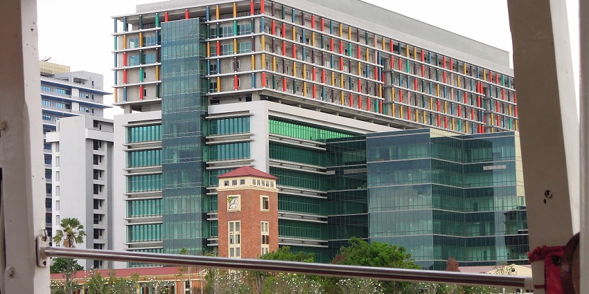 Entrance of Siriraj Hospital with a flag on top of the entrance and modern architecture.
