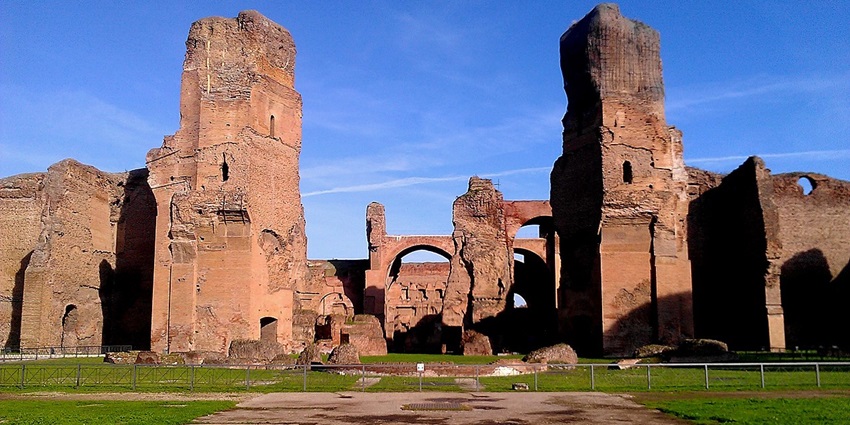 Baths of Caracalla with old ruined architecture, steel fencing and a small signage.