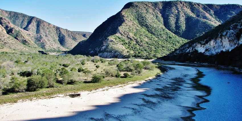 Kouga River in the Baviaanskloof wilderness area with sandy shorelines, greenery and hills, one of the hidden places in South Africa.