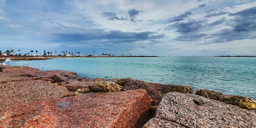 South Padre Island’s sandy beach with clear turquoise waters, ideal for sunbathing and water sports.