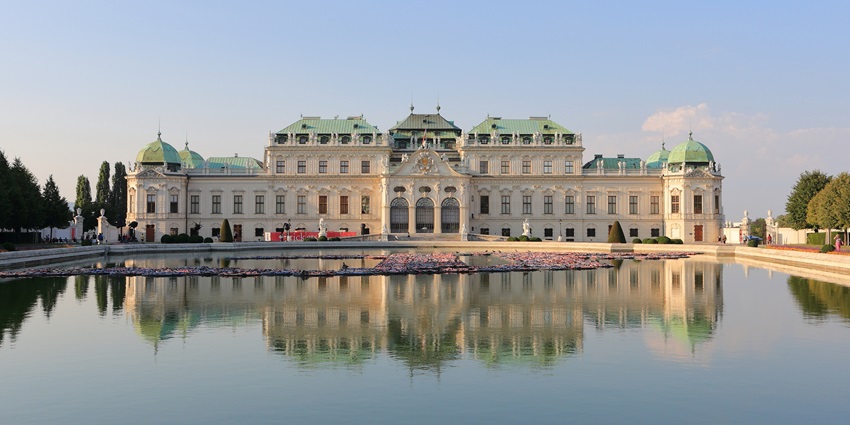 Belvedere Palace in Vienna with a beautiful reflection of its historic architecture and clear blue sky.