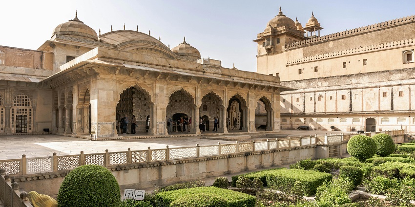 Inside the courtyard of Amber fort with the sun hues reflecting the majestic architecture
