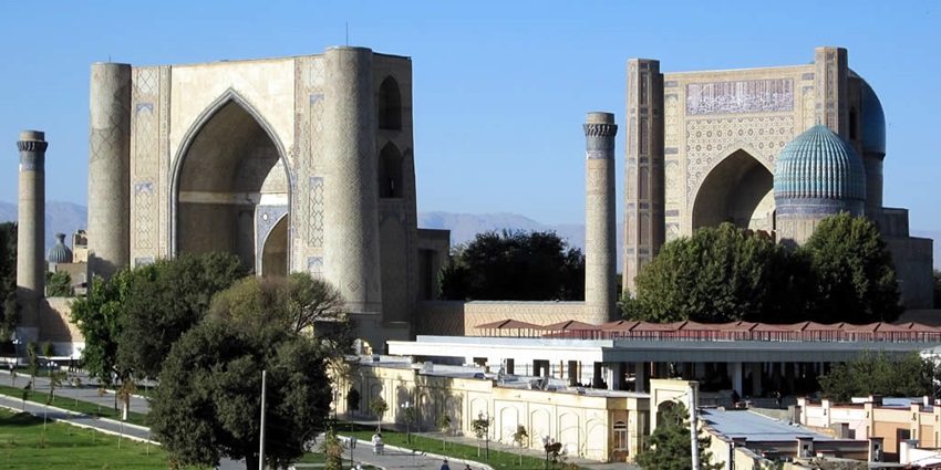 Bibi-Khanym Mosque with big mosque buildings, multiple minarets and people on the road