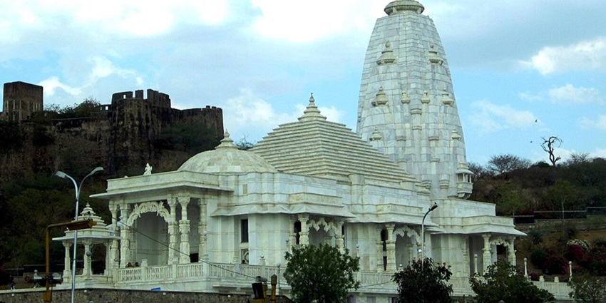 Modern marble temple dedicated to Lord Vishnu, glowing white against the pink cityscape.