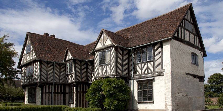 Tudor-style Blakesley Hall with timber-framed exterior and manicured gardens.