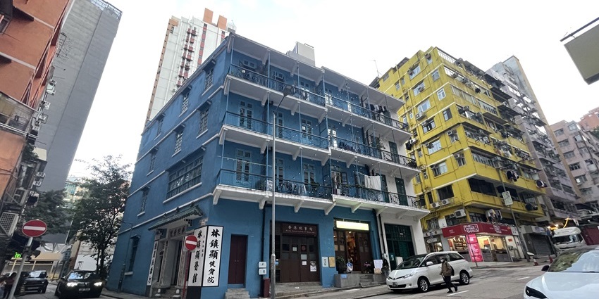 Vibrant tenement buildings painted in blue, yellow, and orange hues with balconies.