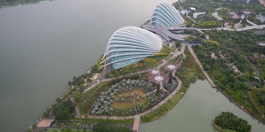 An aerial view of a landscape in Singapore, located by the side of a huge water body.