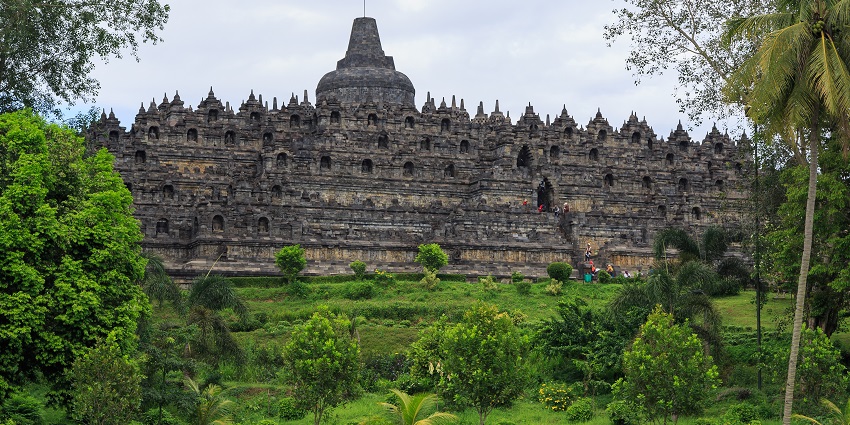 An image of the Borobudur Temple in Indonesia on a sunny day with cloudy blue skies.