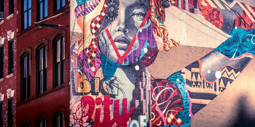 Colorful urban murals painted on brick walls in DUMBO’s open-air gallery in New York