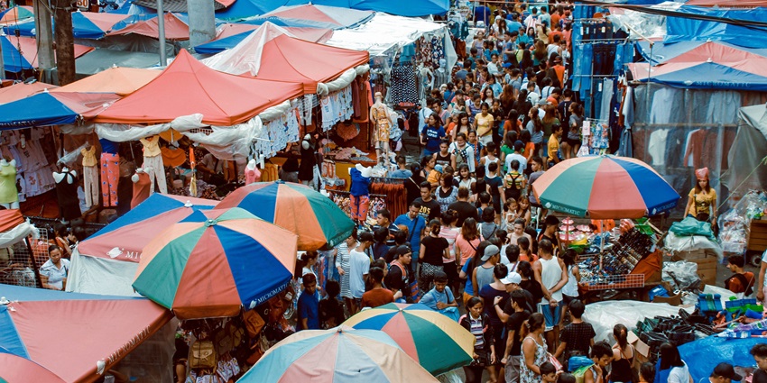 Thong Sala Night Market with colorful stalls, cheerful crowd, and street food under bright lights.