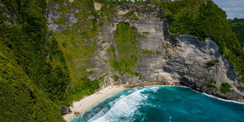 Bukit Asah Bugbug cliffs overlook the ocean, surrounded by lush green vegetation, one of the places to visit in Bali in February.