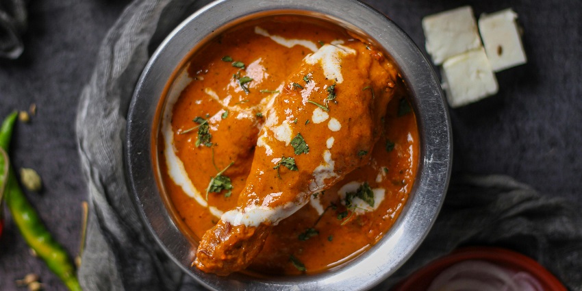 Creamy butter chicken served with naan – what is famous in Delhi to eat