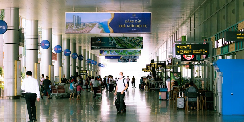 Interior view of an international airport terminal with signage and check-in counters.