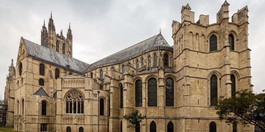 Canterbury Cathedral in Kent with traditional Gothic architecture and small green trees