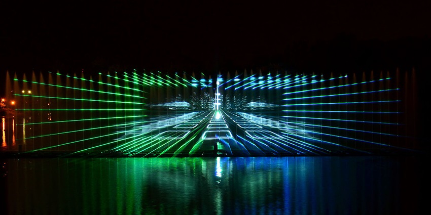 Night view of the Roshen Fountain with vibrant coloured jets dancing above the river.