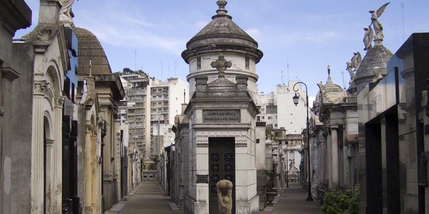 Elegant mausoleums at Recoleta Cemetery are surrounded by marble sculptures and walkways.