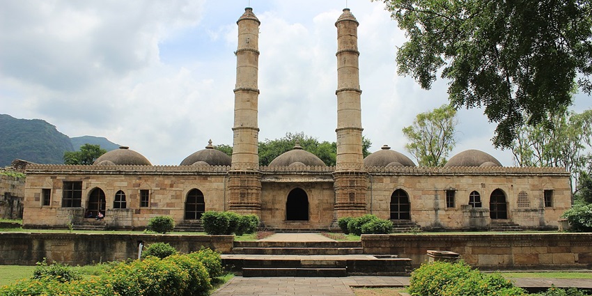 UNESCO-listed site with Islamic and Hindu ruins nestled amidst hills and greenery.