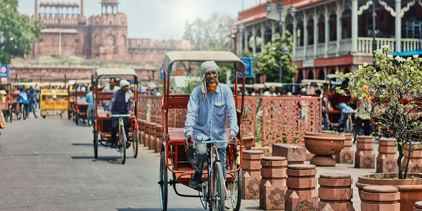 Road in Chandni Chowk market with the Red Fort in the background, one of the places to visit in Delhi in May.