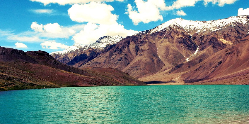 Lake with turquoise waters surrounded by barren mountains under a blue clear sky, one of the best places to visit in Lahaul and Spiti.