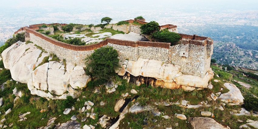 The ancient stone fort was built atop a large rocky hill, surrounded by greenery and distant views