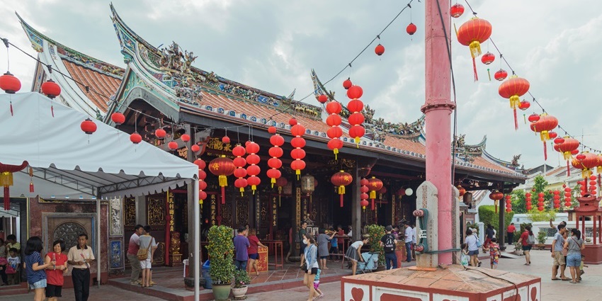 Ornate roof and entrance of Cheng Hoon Teng Temple with red lanterns.