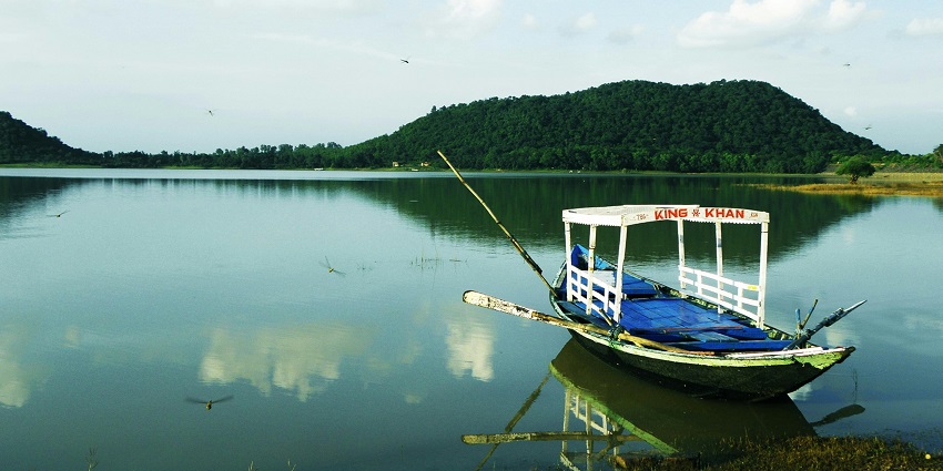 Scenic view of Chilika Lake with a boats near the sandy shore, one of the top places to visit in Odisha in November.