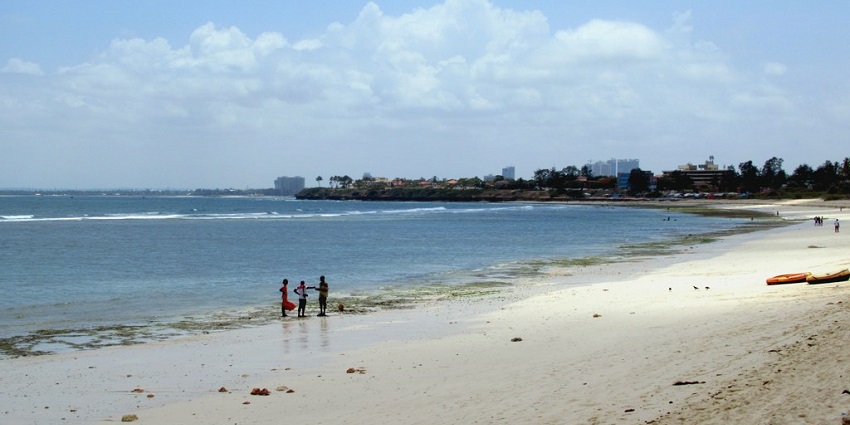 Golden sands, scattered rocks, and ocean waves at Cocoa Beach capture beach vibes and things to do in Dar es Salaam.