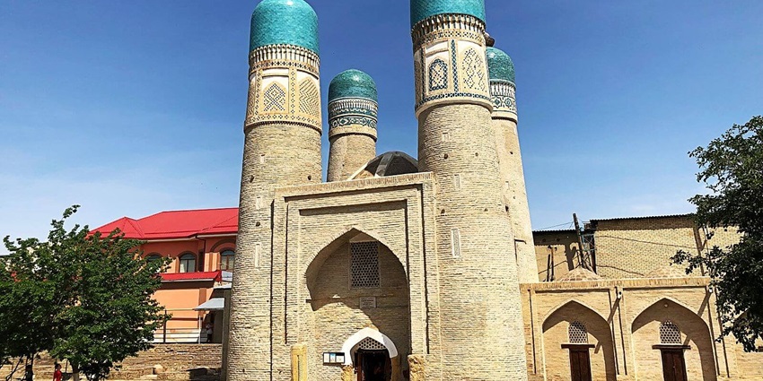 Chor Minar in Bukhara with four minarets, small entry gates and buildings in the back