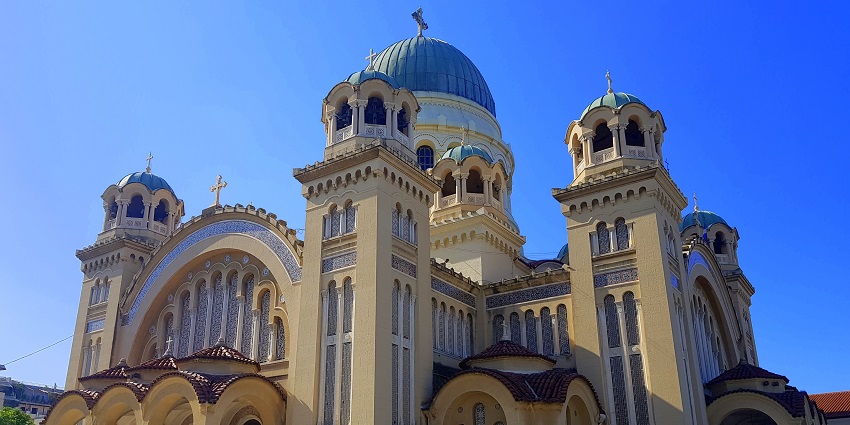 View of a tall Saint Spyridon church against a blue sky with architectural details.