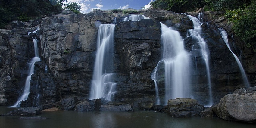 Steep steps lead down to a serene waterfall where nature’s magnificence and peace combine.
