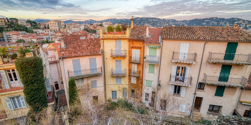 Cobbled street and pastel homes climbing uphill, showcasing quiet things to do in Cannes.