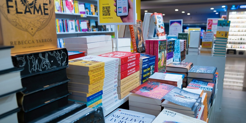 Books on display at a busy street-side shop with a wide variety of genres available.