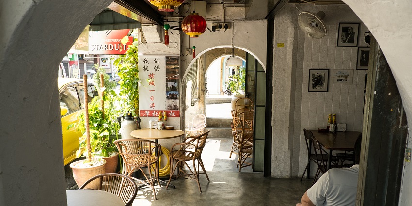A view of a cafe on a lazy afternoon with a single customer awaiting the arrival of food.
