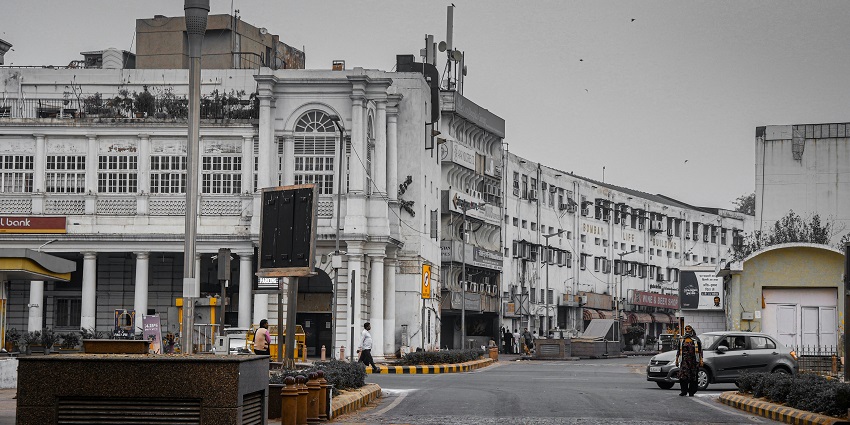 Connaught Place with white concrete architectural buildings and vehicles, one of the top places to visit in Delhi in May.