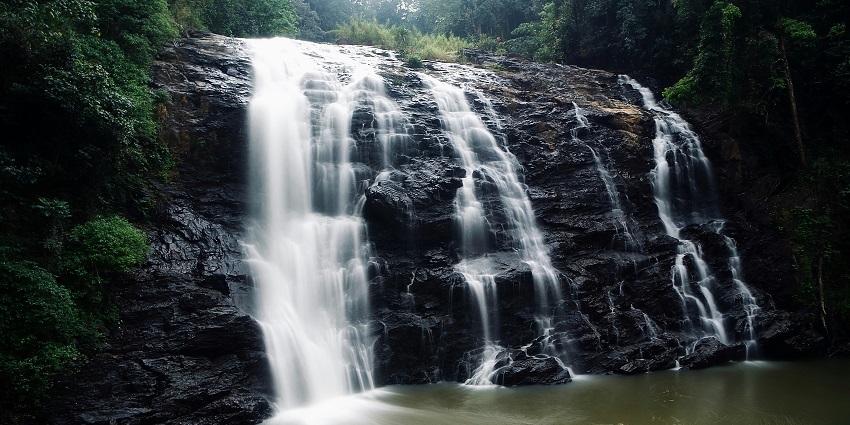 A scenic view of cascading waterfall in Coorg, one of the top places to visit in Karnataka in February.