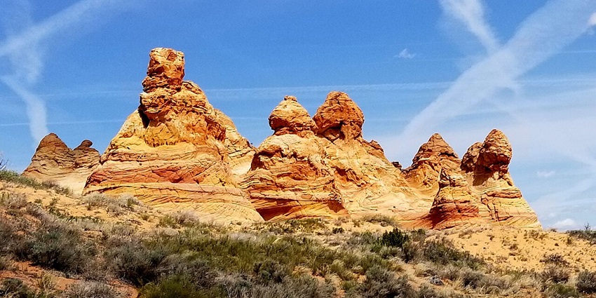 Coyote Buttes South with natural, unique rocky mountains surrounded by green bushes, one of the hidden places in Arizona.