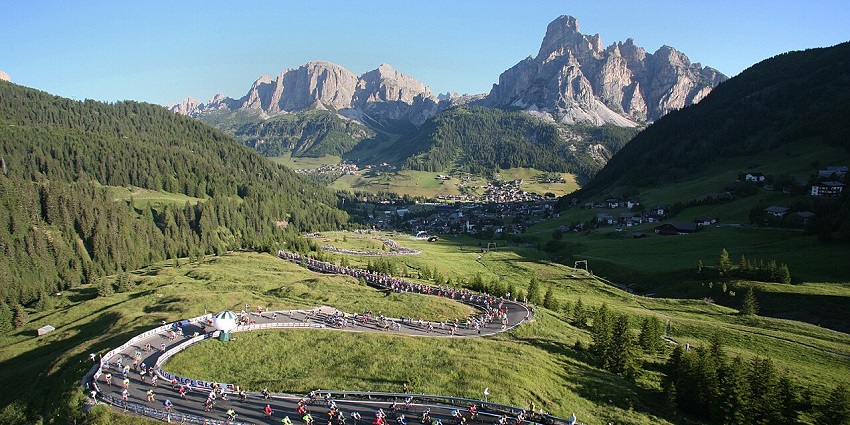 Cyclist riding a mountain bike along the Sella Ronda circuit trails.