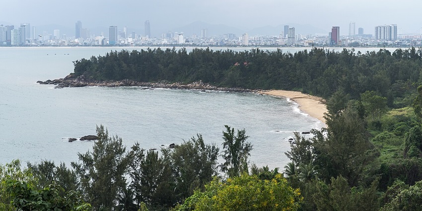 Scenic view of Da Nang city with a river surrounded by lush greenery and an urban skyline.