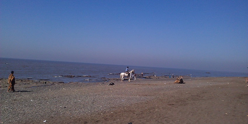 Visitors enjoying the serene shoreline of Dabhari Beach, a peaceful coastal getaway near Surat.