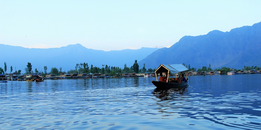 Shikara boats floating on the calm waters of Dal Lake with a mountain backdrop, amongst the top places to visit in Jammu in January.