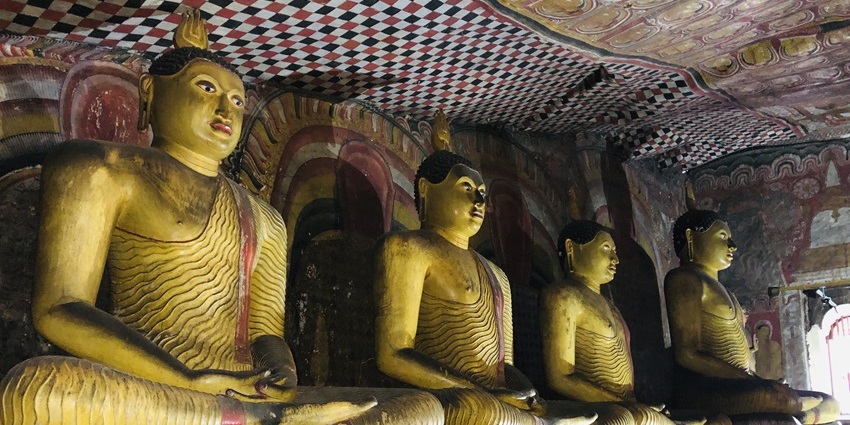 Interior of Dambulla Cave Temple with Buddha statues and vivid murals.