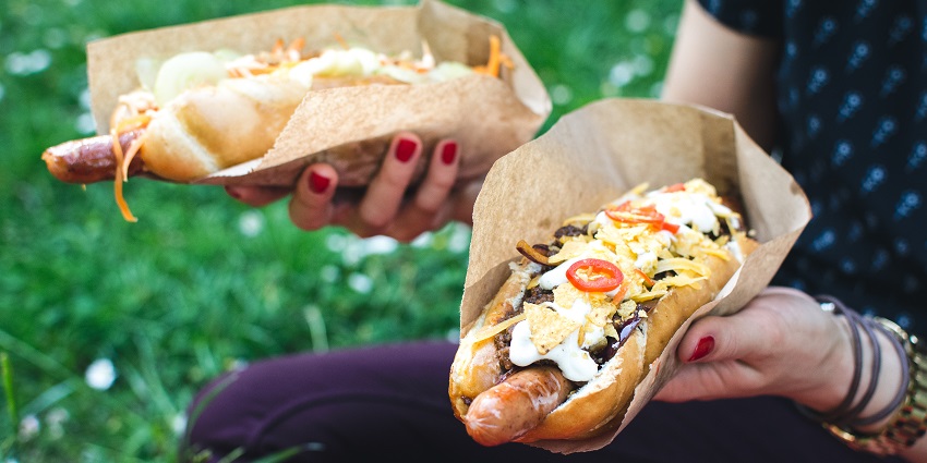 An image of a Danish hotdog with toppings like remoulade, onions, pickles, and mustard.