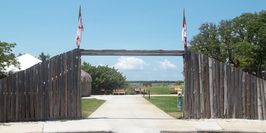 De Soto National Memorial with two flags on top of the wood, a distant bench, Florida